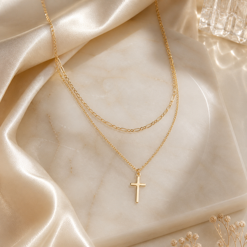 Cute n Covered Necklace is a Gold necklace with a cross pendant on a marble surface